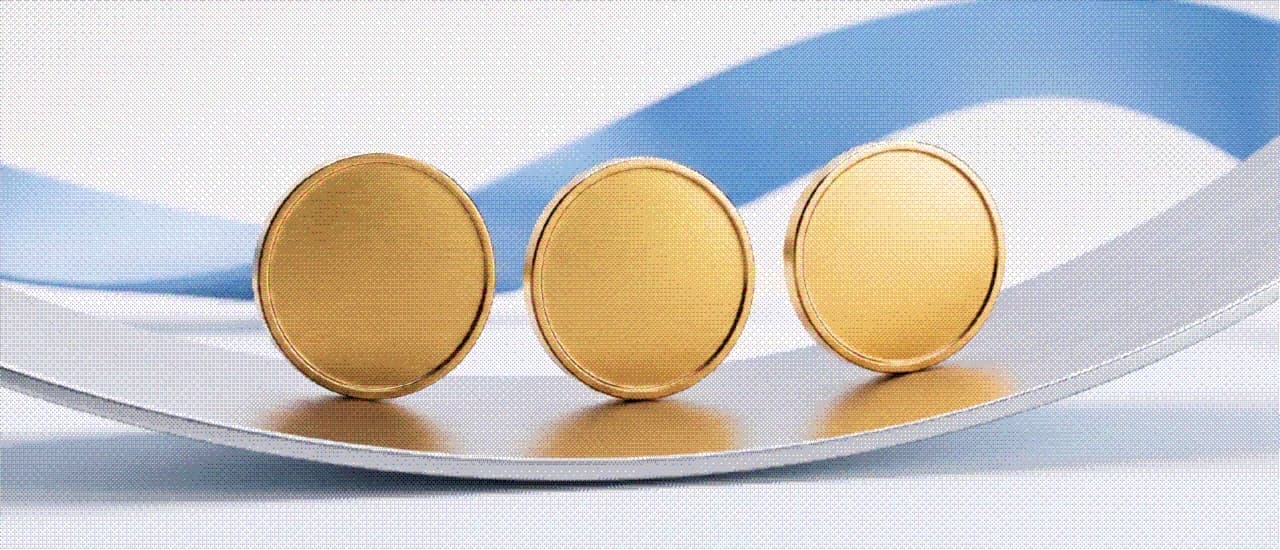 Three gold coins resting on a rippled blue surface
