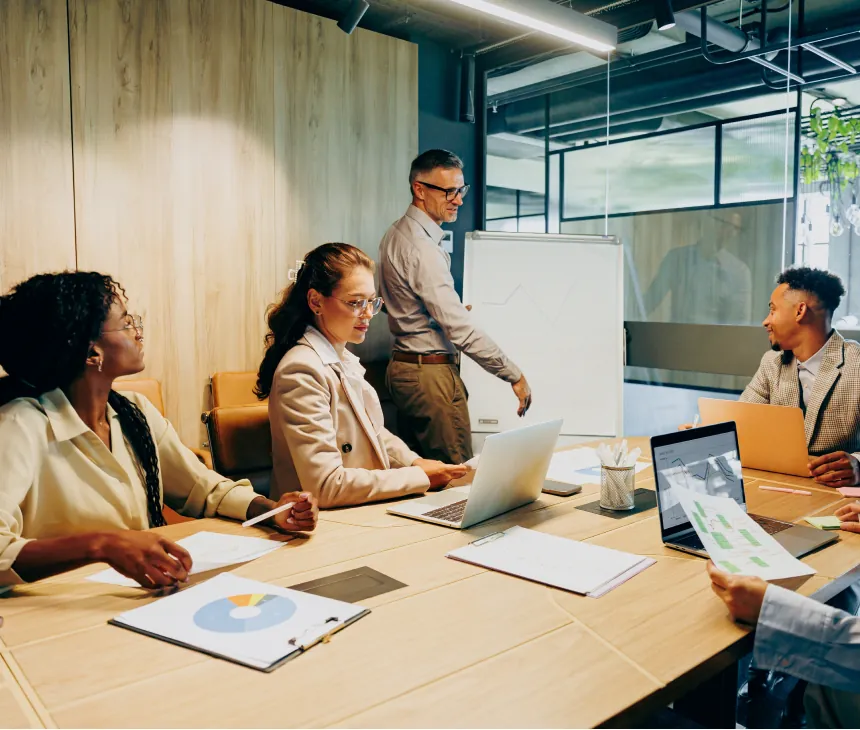 A team meeting around a table in a glass-walled office