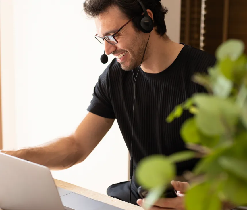A consultant wearing a headset working at a laptop